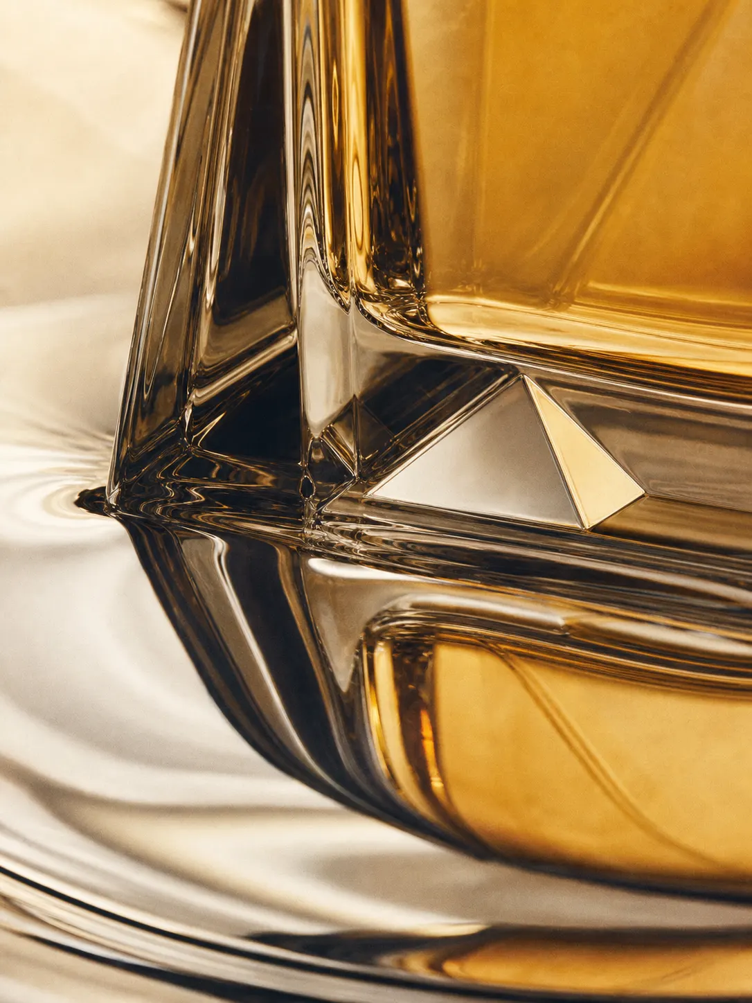 Faceted glass base with amber light on a chrome surface.